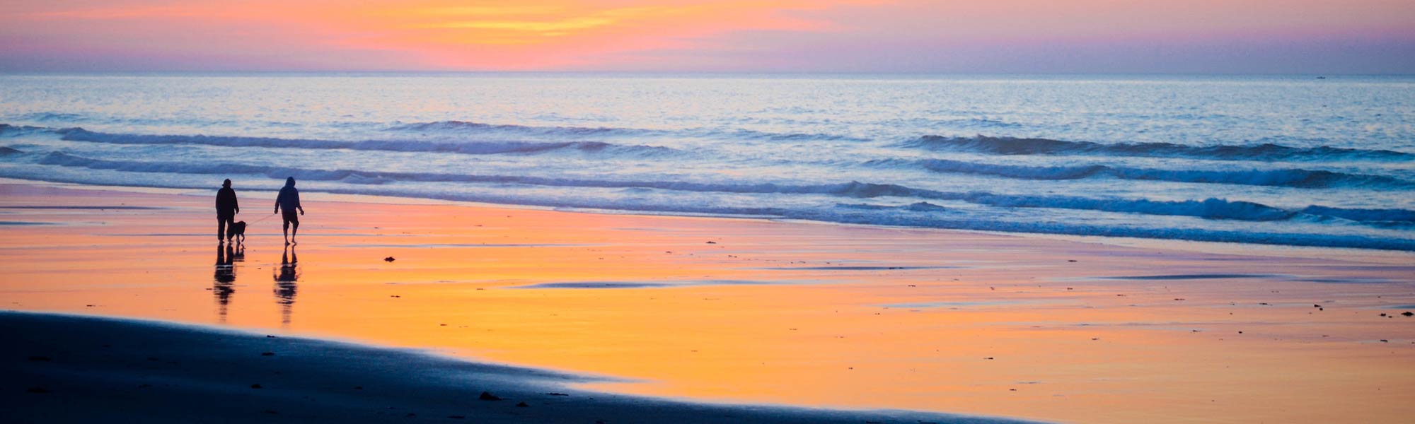 Familie am Strand im Sonnenuntergang